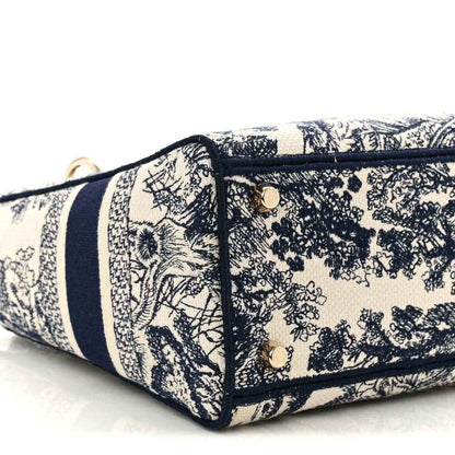 Blue toile de Jouy handbag base close-up showing navy trim and stitched side panel.
