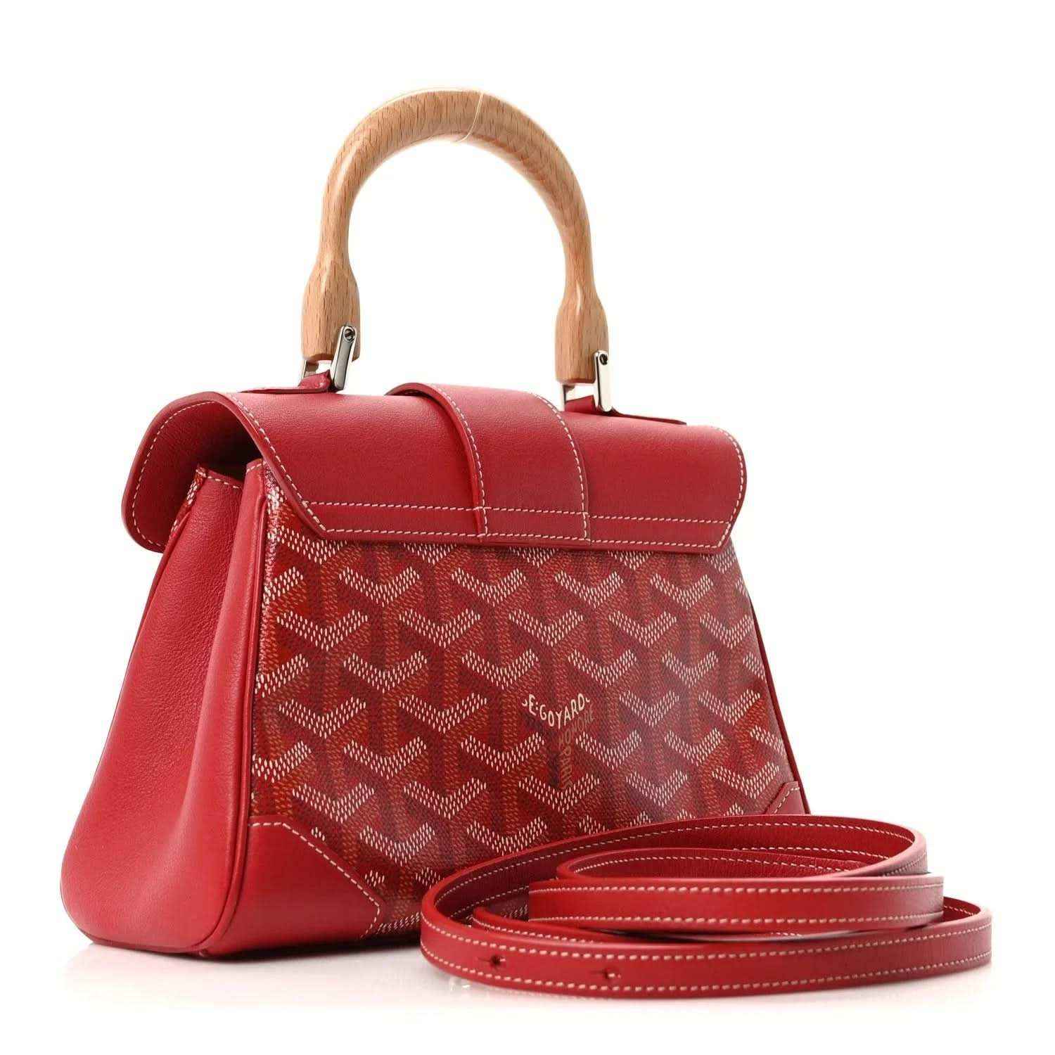 Red mini handbag with top handle, flap, patterned coated canvas, and crossbody strap.