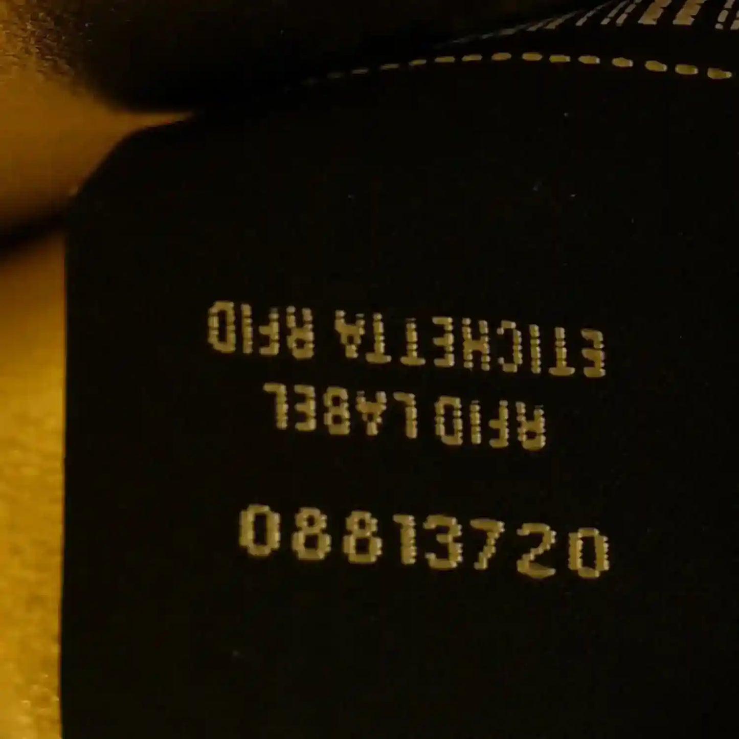 Black fabric label with reversed serial text and numbers on the bag interior