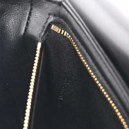 Black leather close-up with gold-tone zipper track and seam details