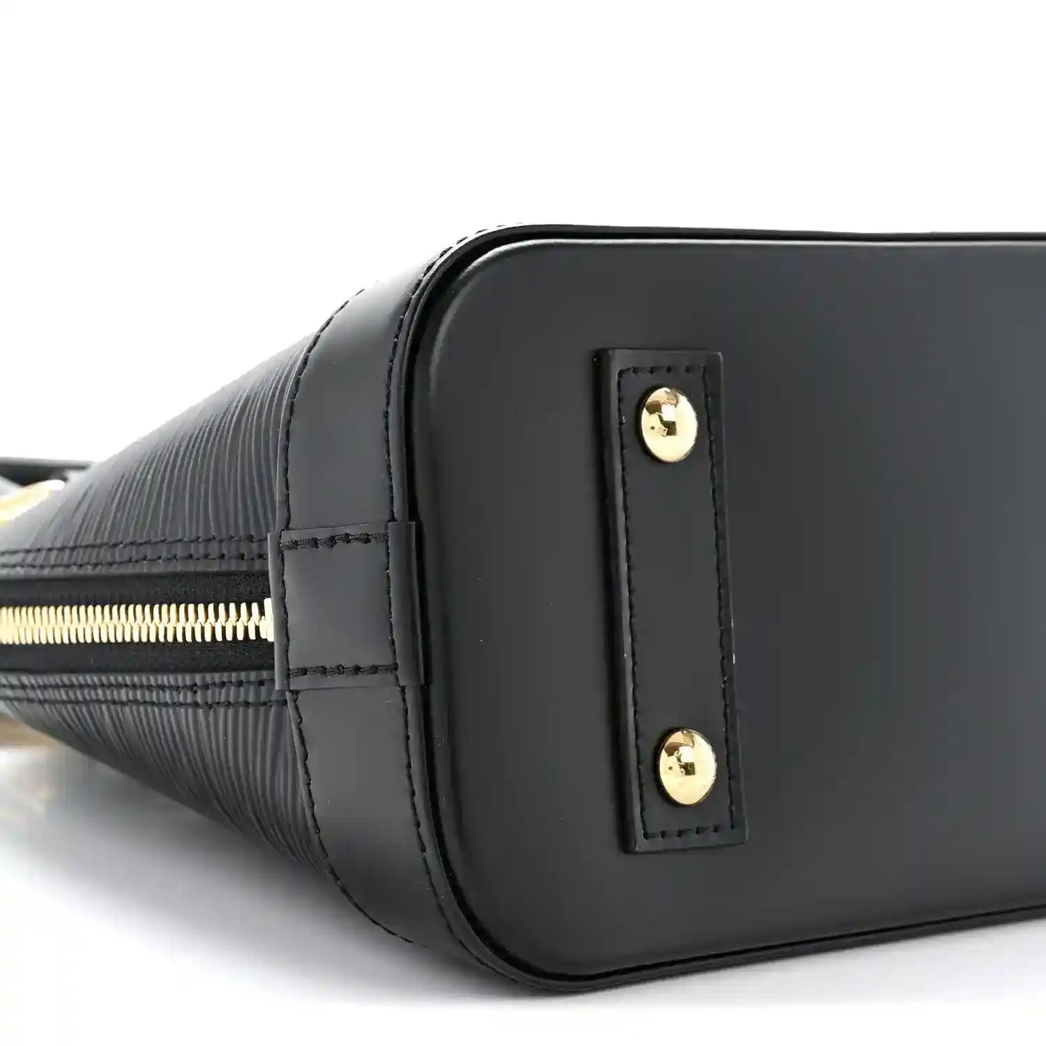 Black handbag side with vertical leather tab and gold-tone studs near zipper