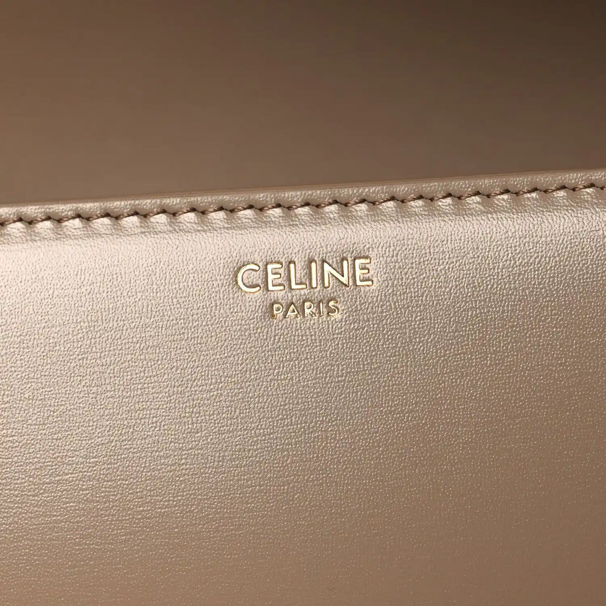 Celine Paris embossed on beige leather with visible edge stitching
