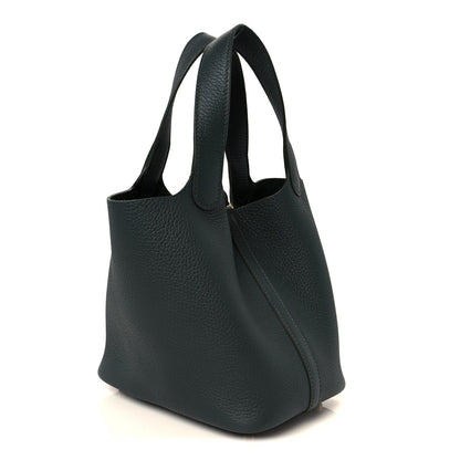 Dark green textured leather tote with two top handles and slanted side panel