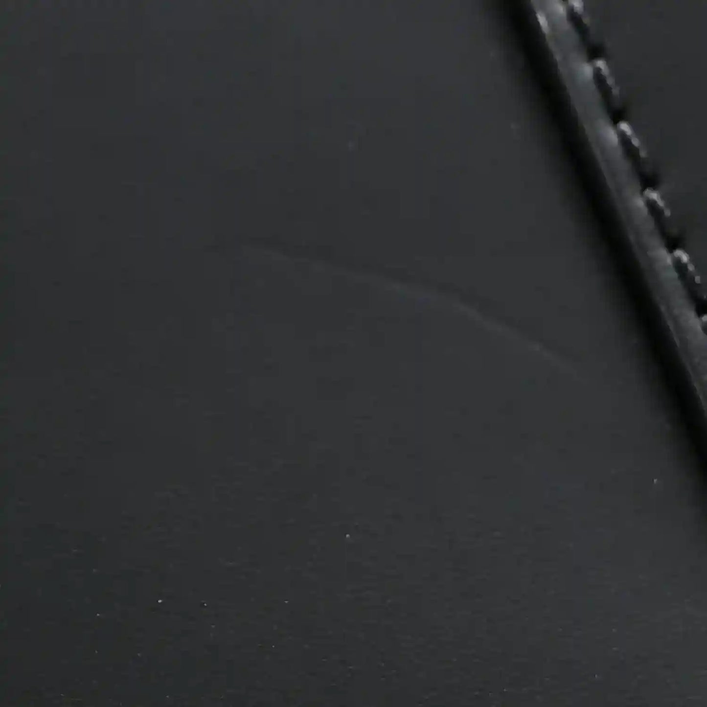 Black textured leather handbag with stitched edge and dark trim