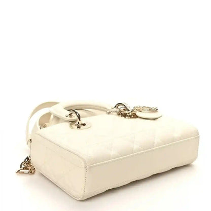 Small white quilted handbag with top flap closure and gold-tone hardware