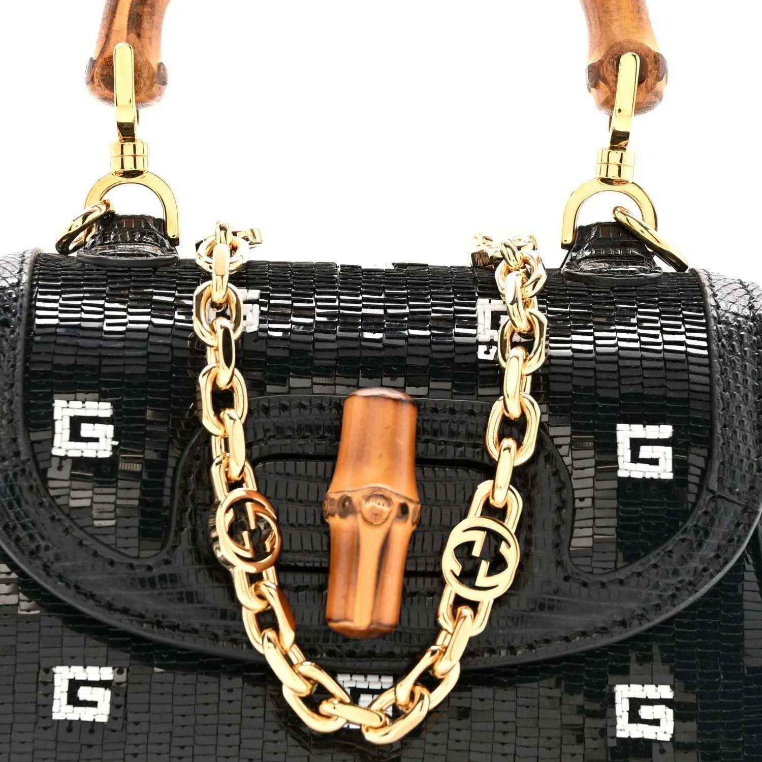 Black mini top handle bag with GG pattern, gold chain strap, and brown bamboo handle inserts