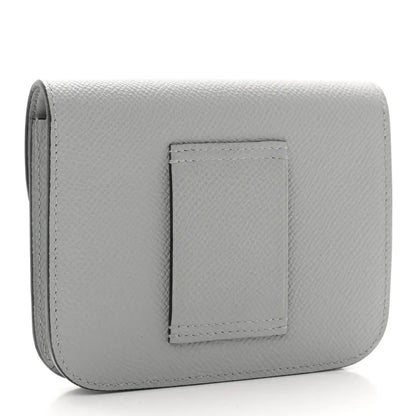 Hermes Constance slim wallet back, light blue textured leather with centered patch.