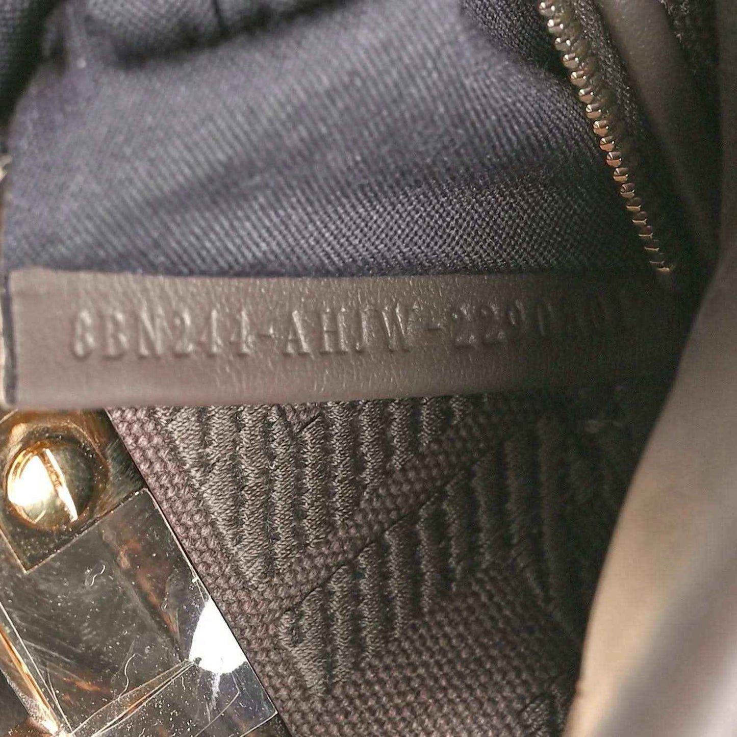 Interior brand label on dark fabric lining with embossed text.