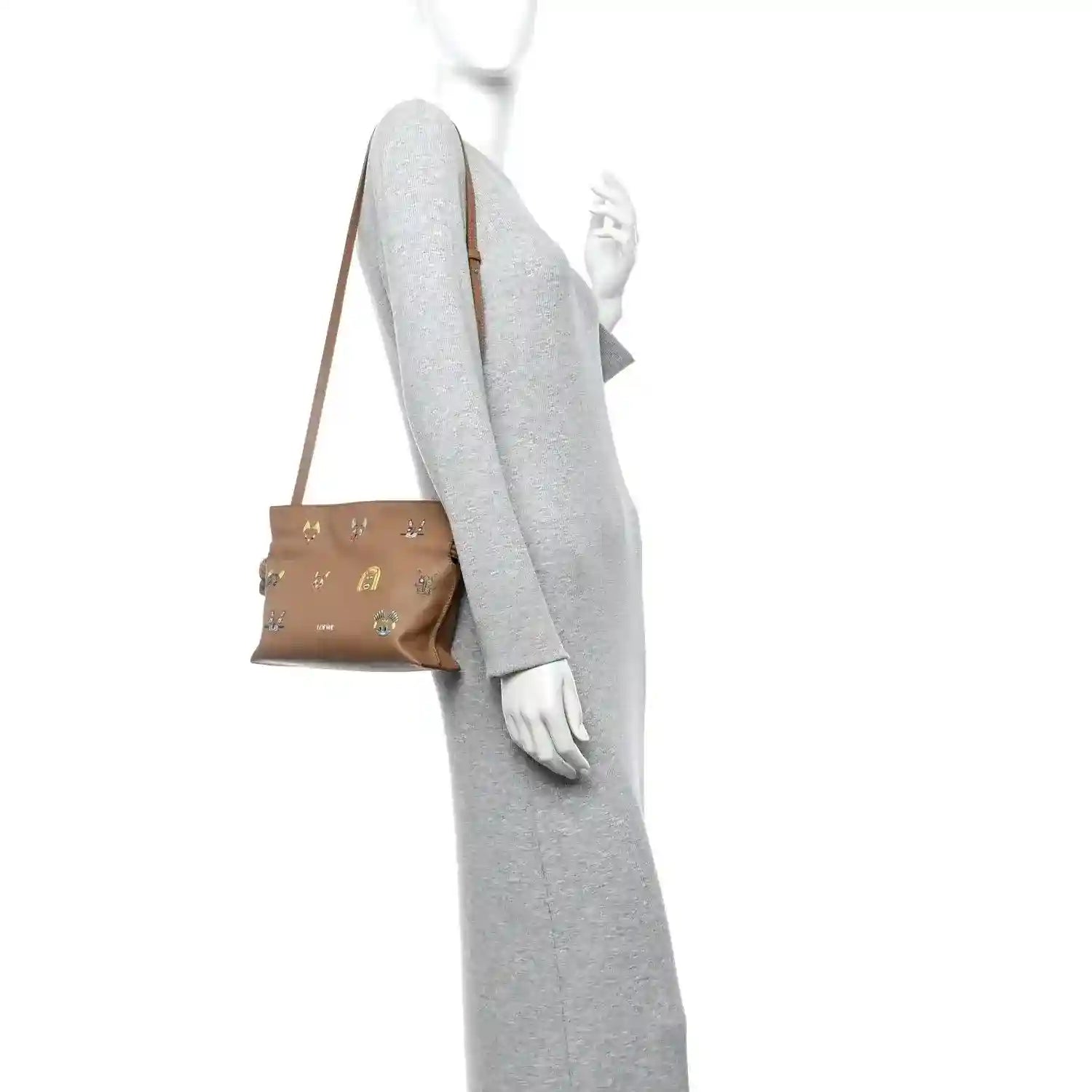Tan mini crossbody clutch with knotted shoulder strap and compact top fold shape.