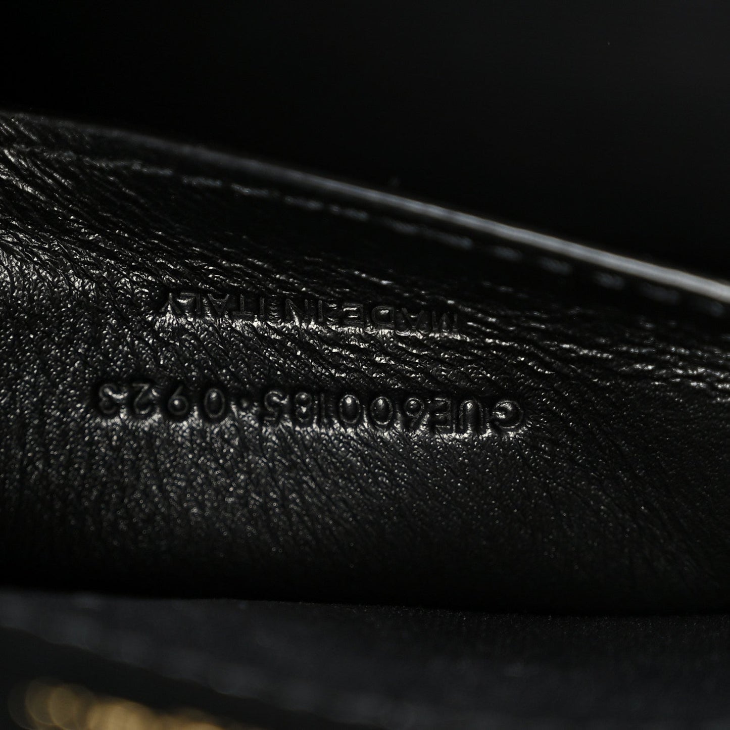 Black leather satchel with embossed serial-style text