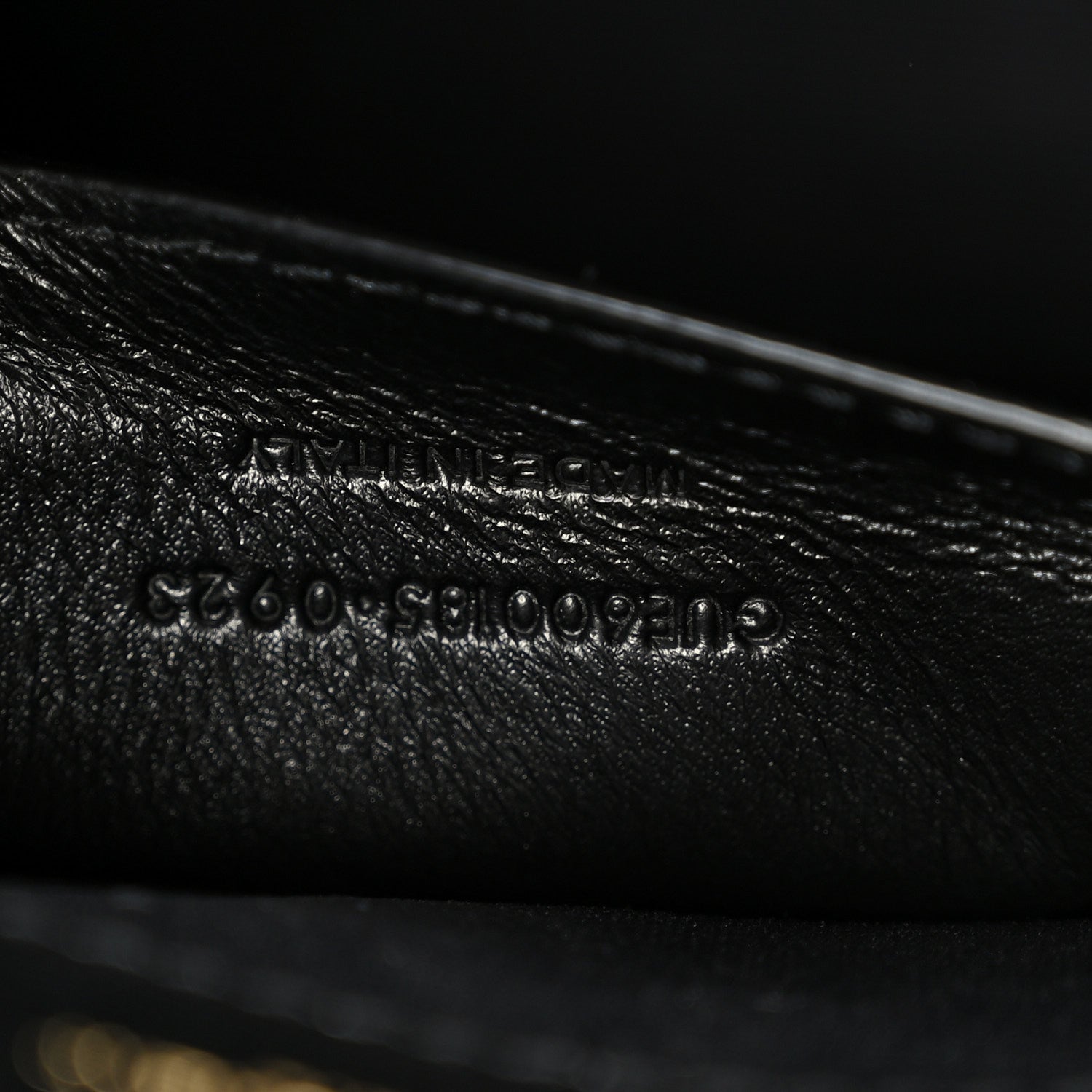 Black leather satchel with embossed serial-style text