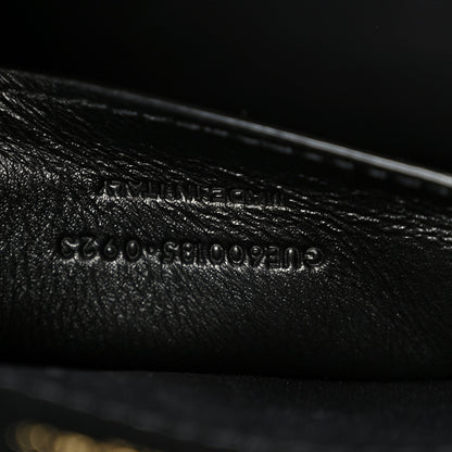 Black leather satchel with embossed serial-style text