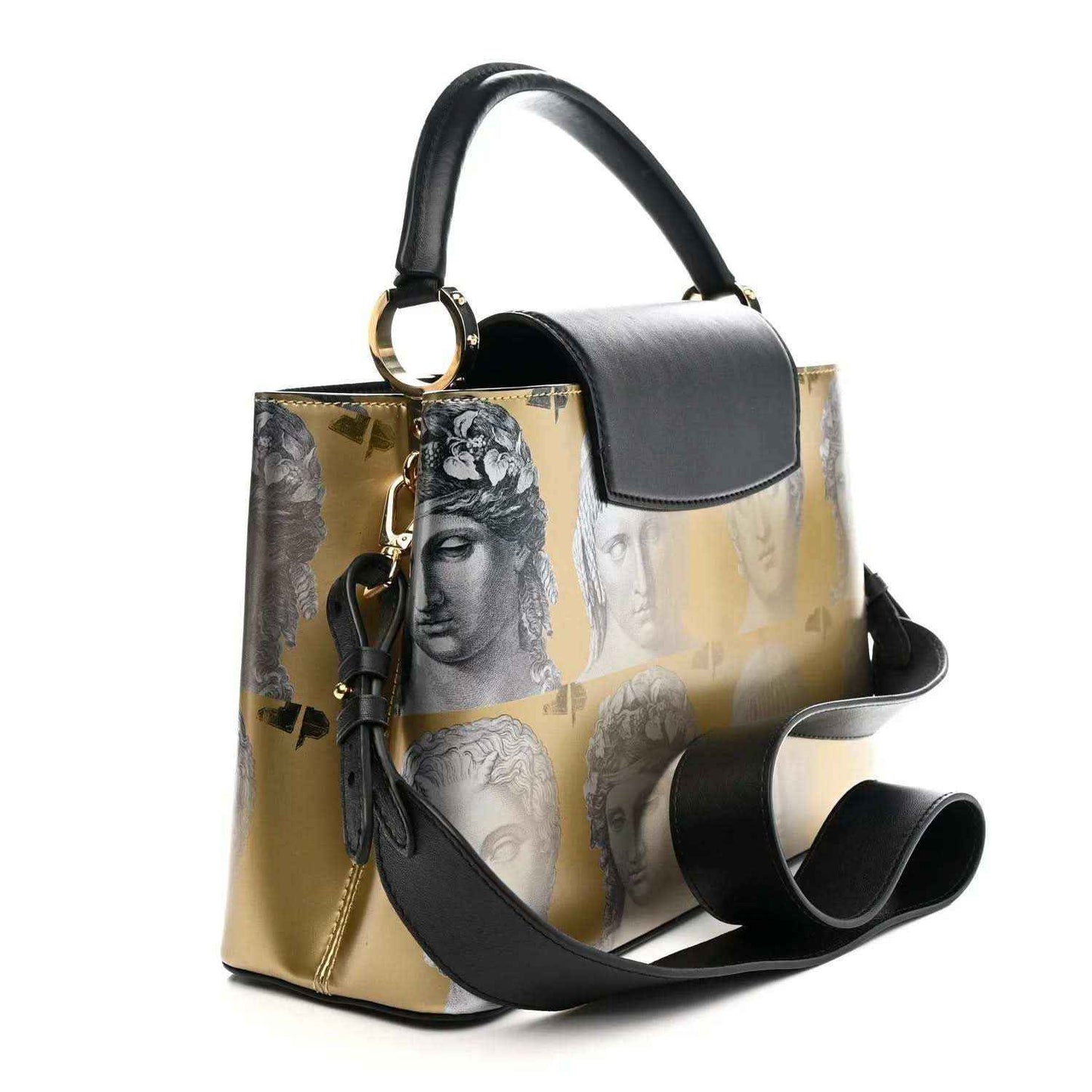 Structured handbag with gold face-print sides, black top handle, and tassel detail
