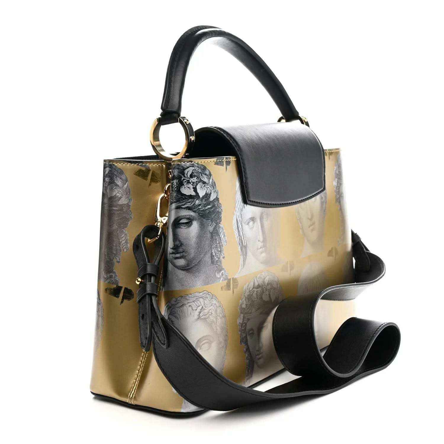 Structured handbag with gold face-print sides, black top handle, and tassel detail