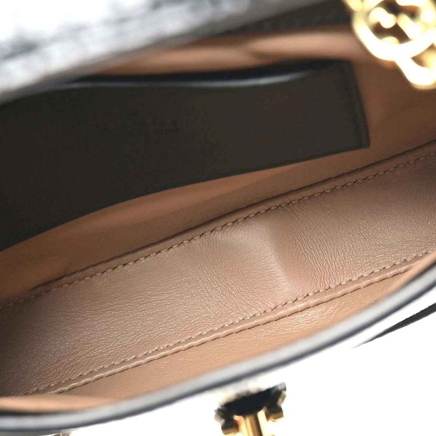 Mini Jackie handbag interior lining with tan leather and gold-tone clasp hardware detail.