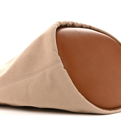 Desert dust canvas tote with brown leather-lined base and curved seam