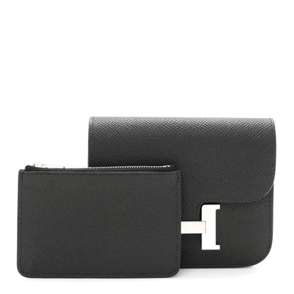 Black slim wallet with flap closed, showing H clasp hardware.