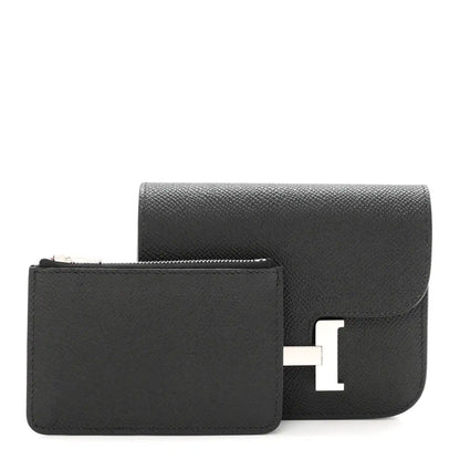 Black slim wallet with flap closed, showing H clasp hardware.