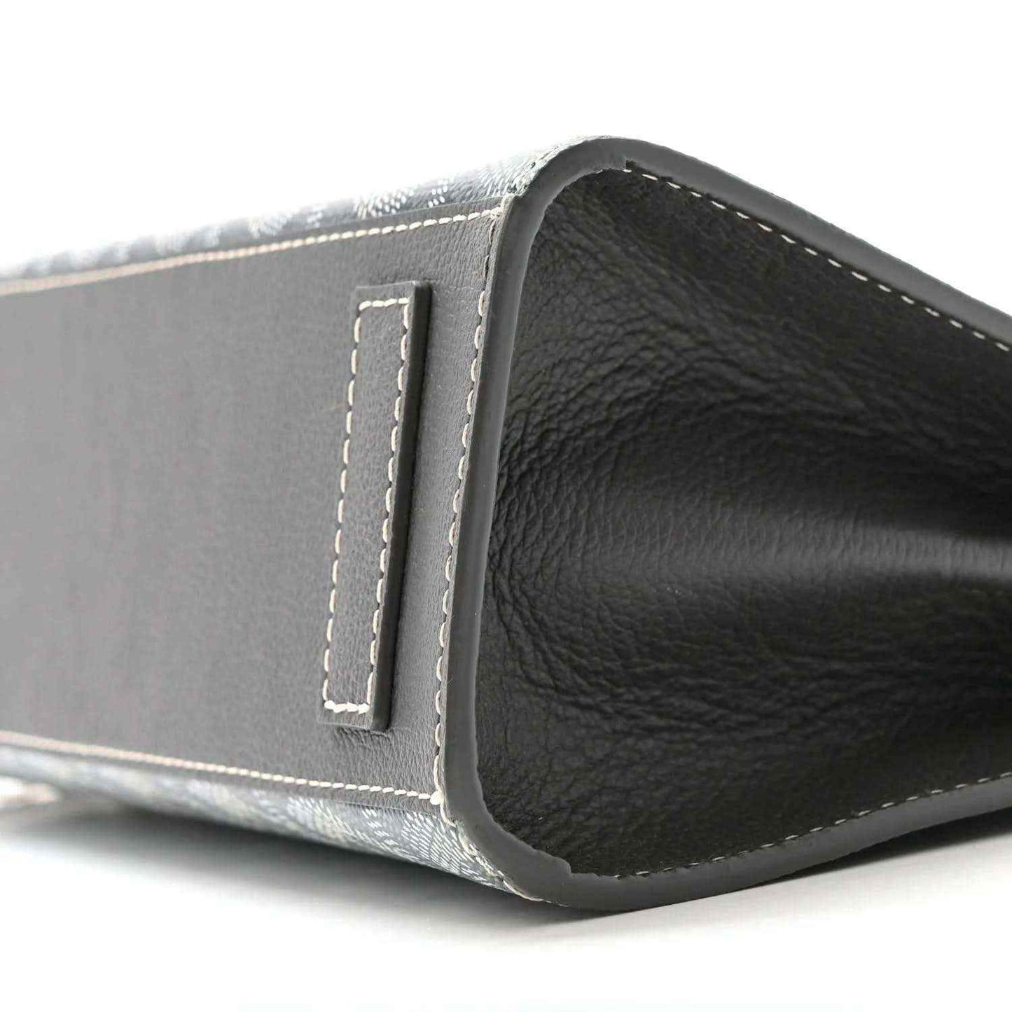 Grey shoulder bag side edge with leather panel and stitched tab, black interior visible