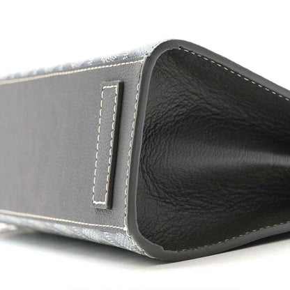 Grey shoulder bag side edge with leather panel and stitched tab, black interior visible