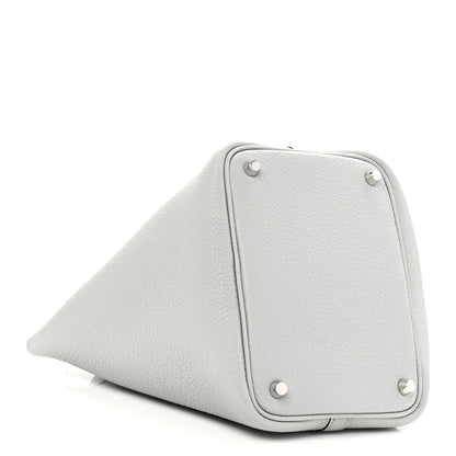 Light blue pebbled leather bucket bag side panel with metal studs and curved base