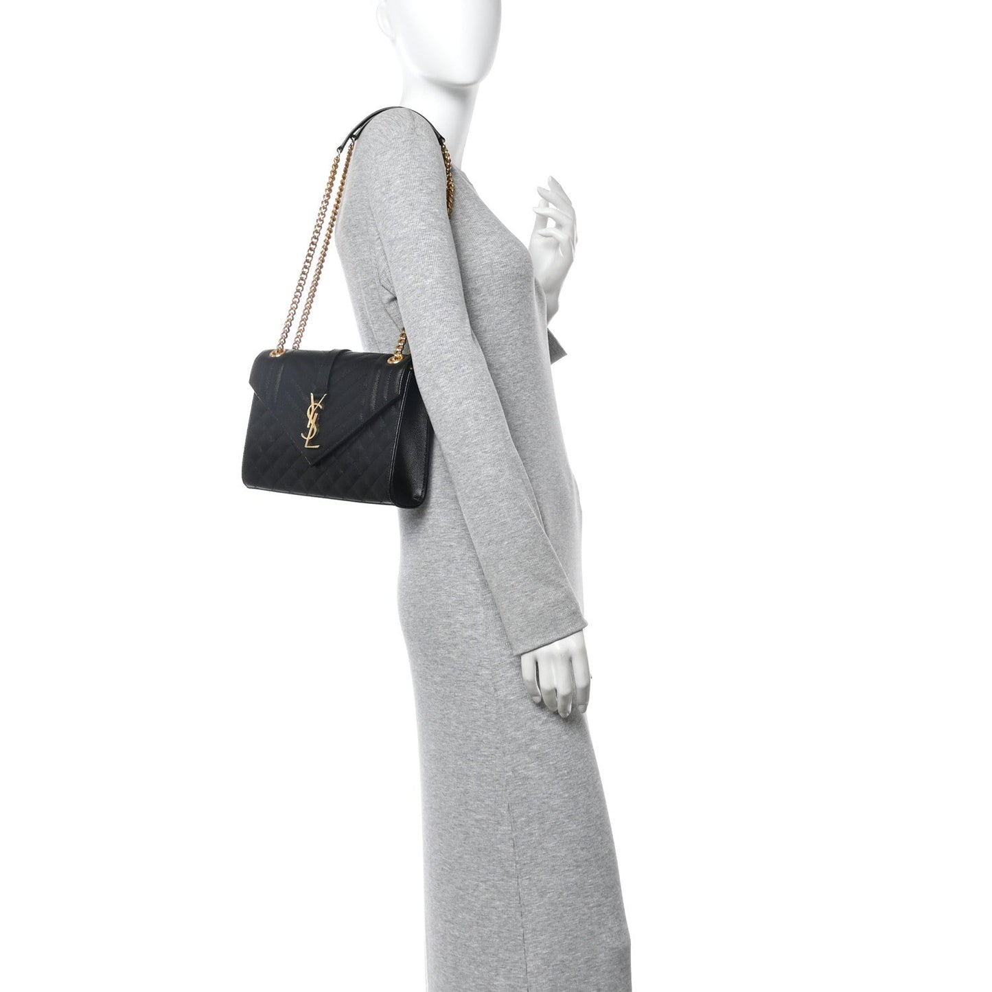 Black leather satchel bag with gold chain shoulder strap worn across the body
