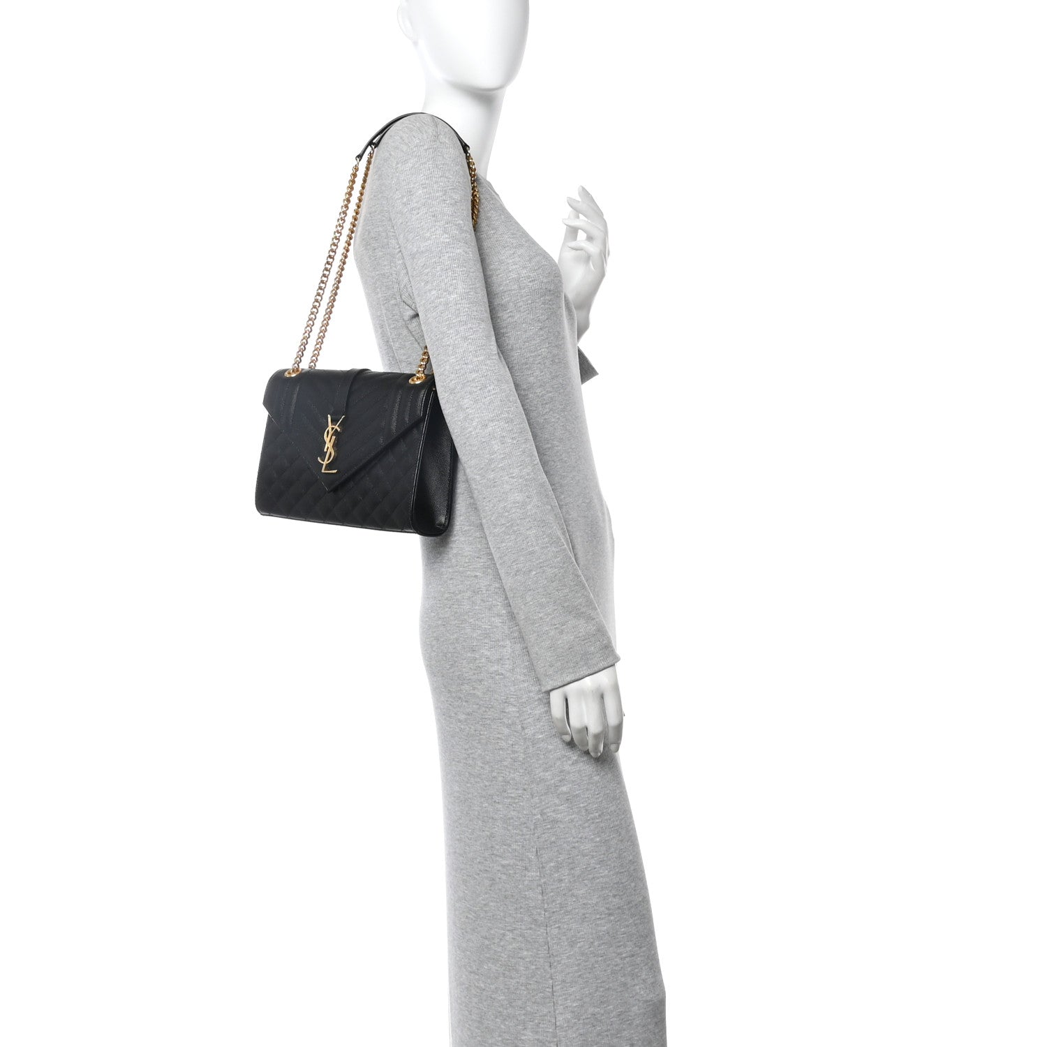 Black leather satchel bag with gold chain shoulder strap worn across the body
