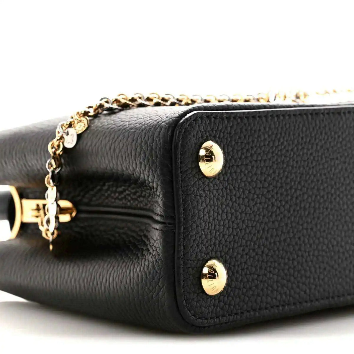 Black leather handbag side panel with two gold snap studs and chain detail