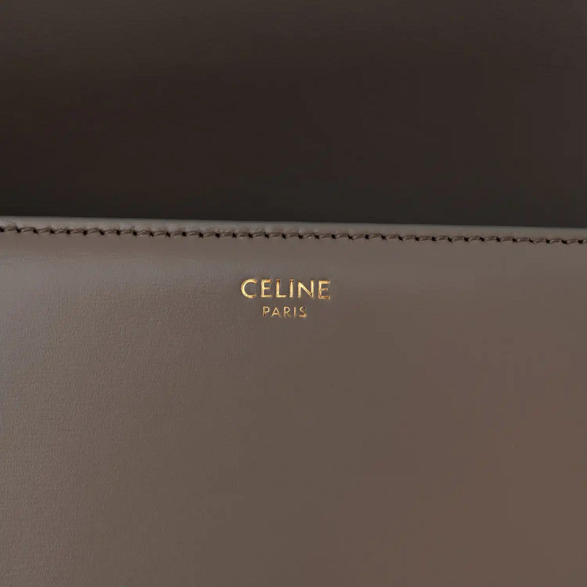 Celine branding on interior of shiny calfskin shoulder bag, gold lettering on dark taupe