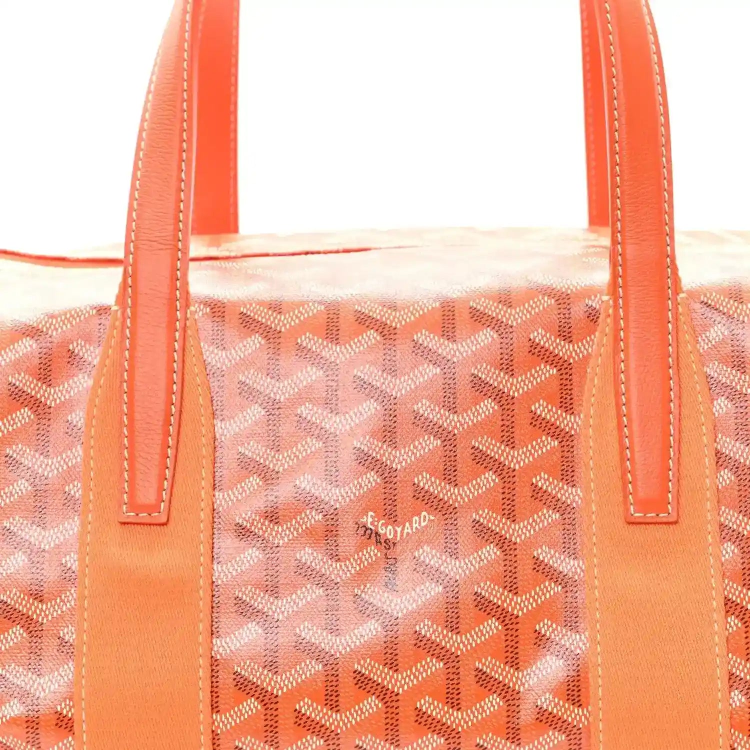 Orange leather-style handles on monogram canvas barrel sports bag.