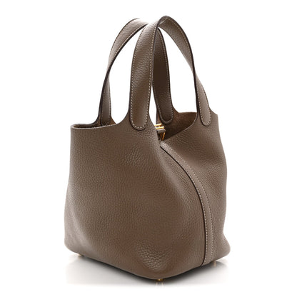 Taupe calfskin leather bucket bag with dual top handles and golden hardware.