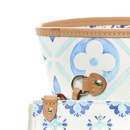 Blue monogram tote bag with tan leather handle straps and gold-tone hardware