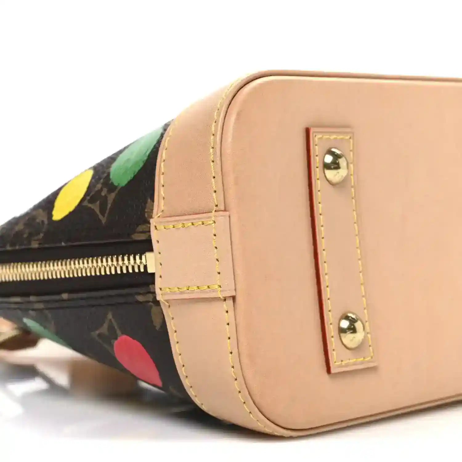 Tan front panel handbag with gold-tone studs and zipper edge over dot-print side.