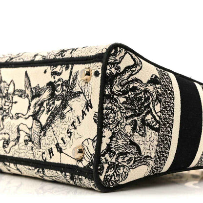 Toile-printed tote bottom corner with black piping and stitched hardware details.