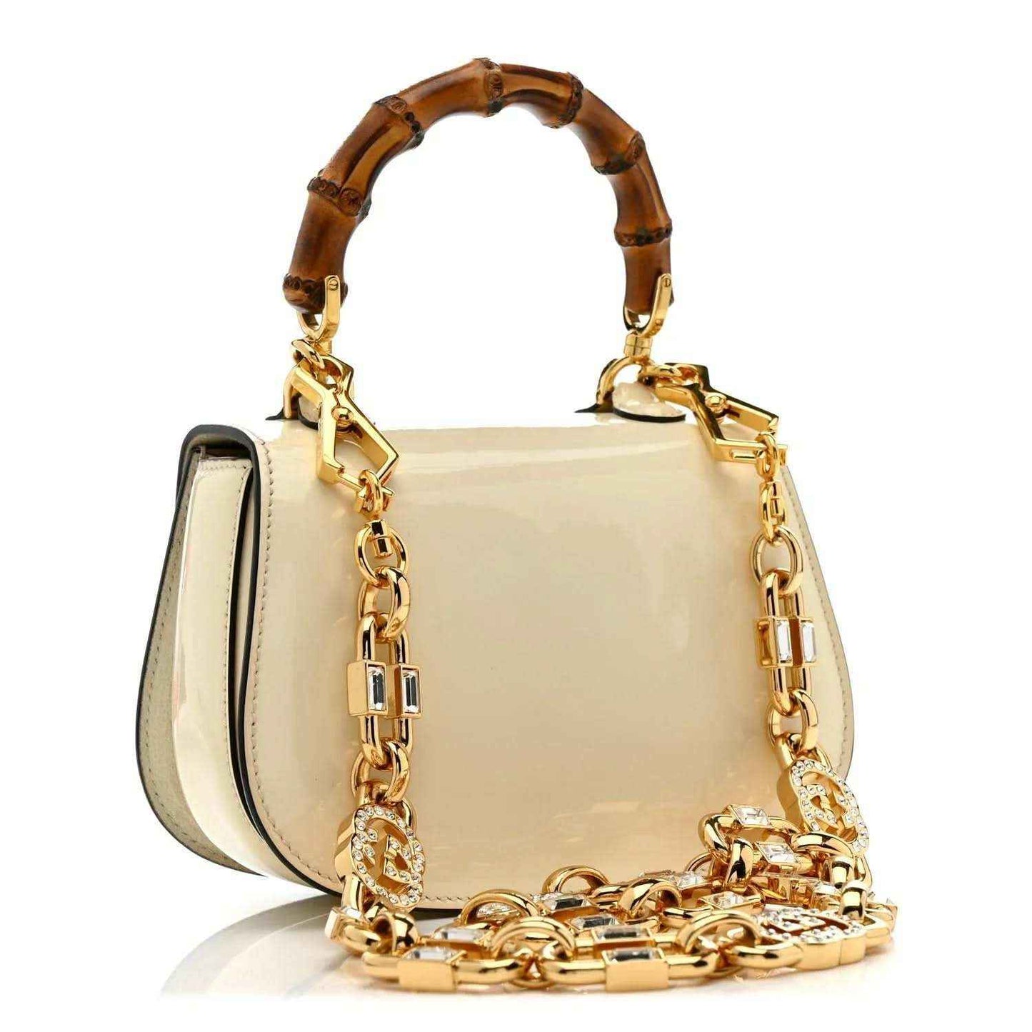 White mini handbag with gold chain strap, bamboo handle, and side profile
