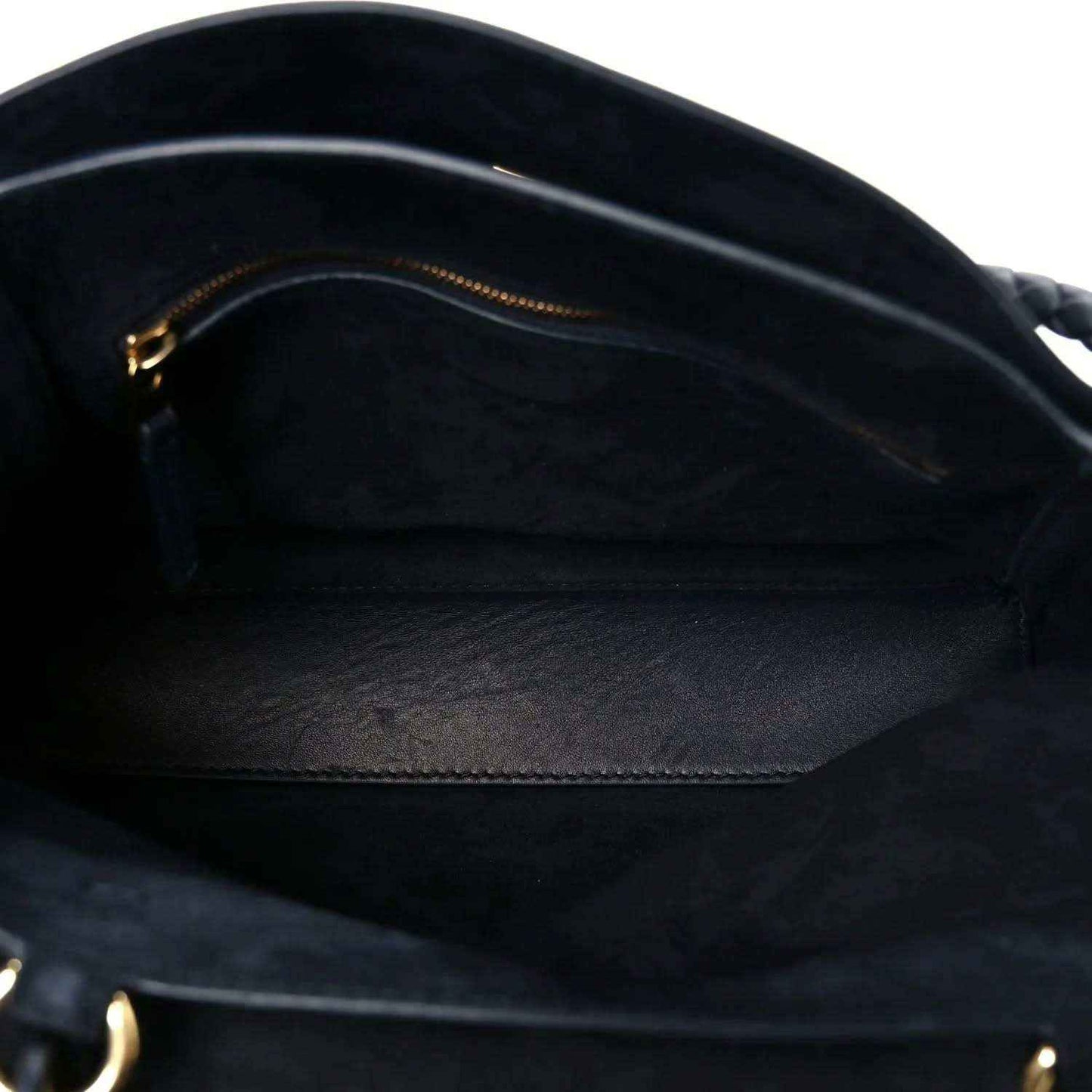 Black handbag interior lining with smooth leather texture and gold zipper trim