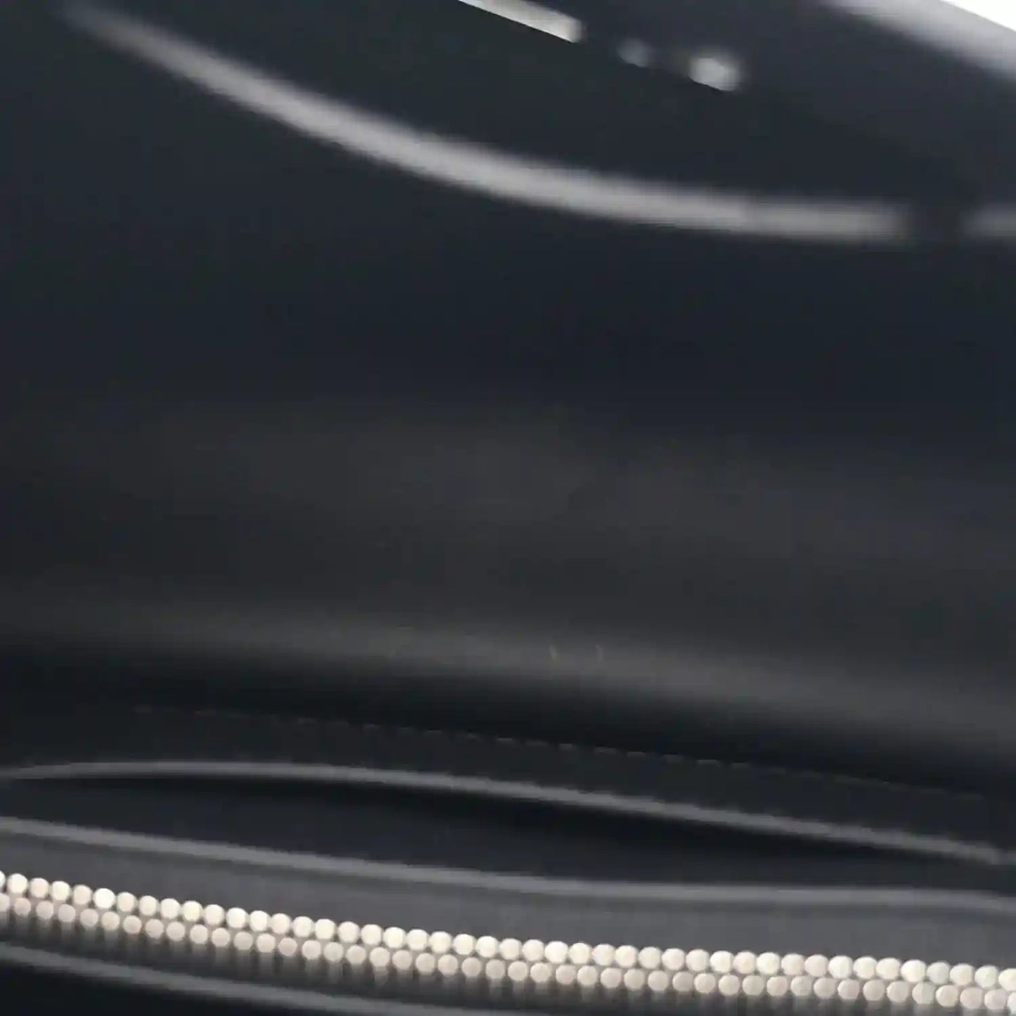 Black leather handbag zipper with silver teeth and zipper pull