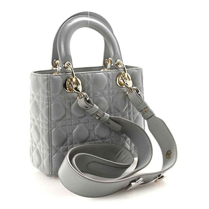 Grey quilted Lady Dior handbag with top handle, shoulder strap, and metal clasp hardware