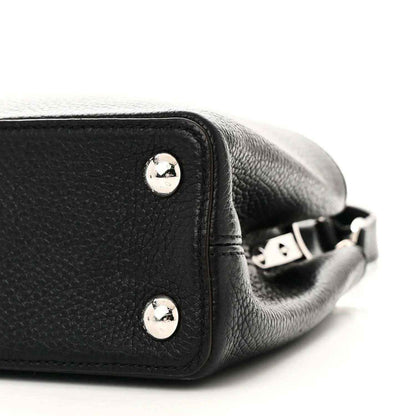 Black leather handbag side with silver studs and adjustable crossbody strap