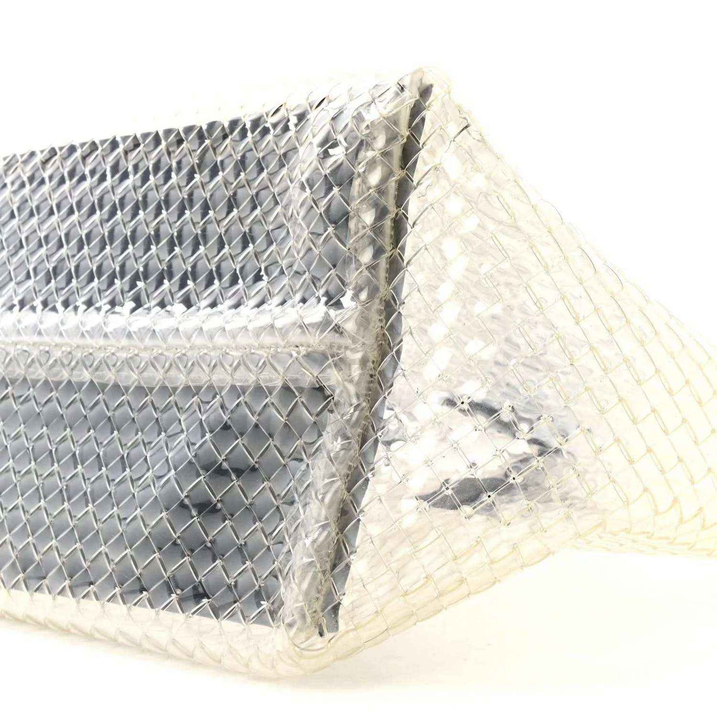 Close-up of woven PVC tote corner with silver-tone panel and white lining