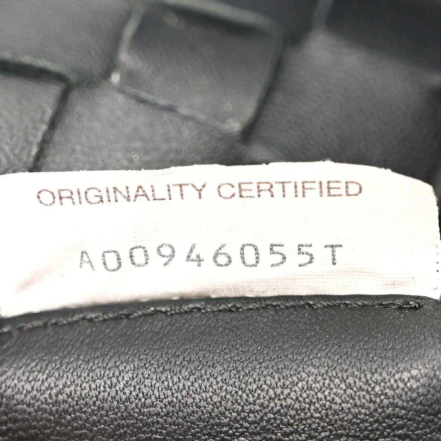 Bottega Veneta originality certified label on black leather bag lining.