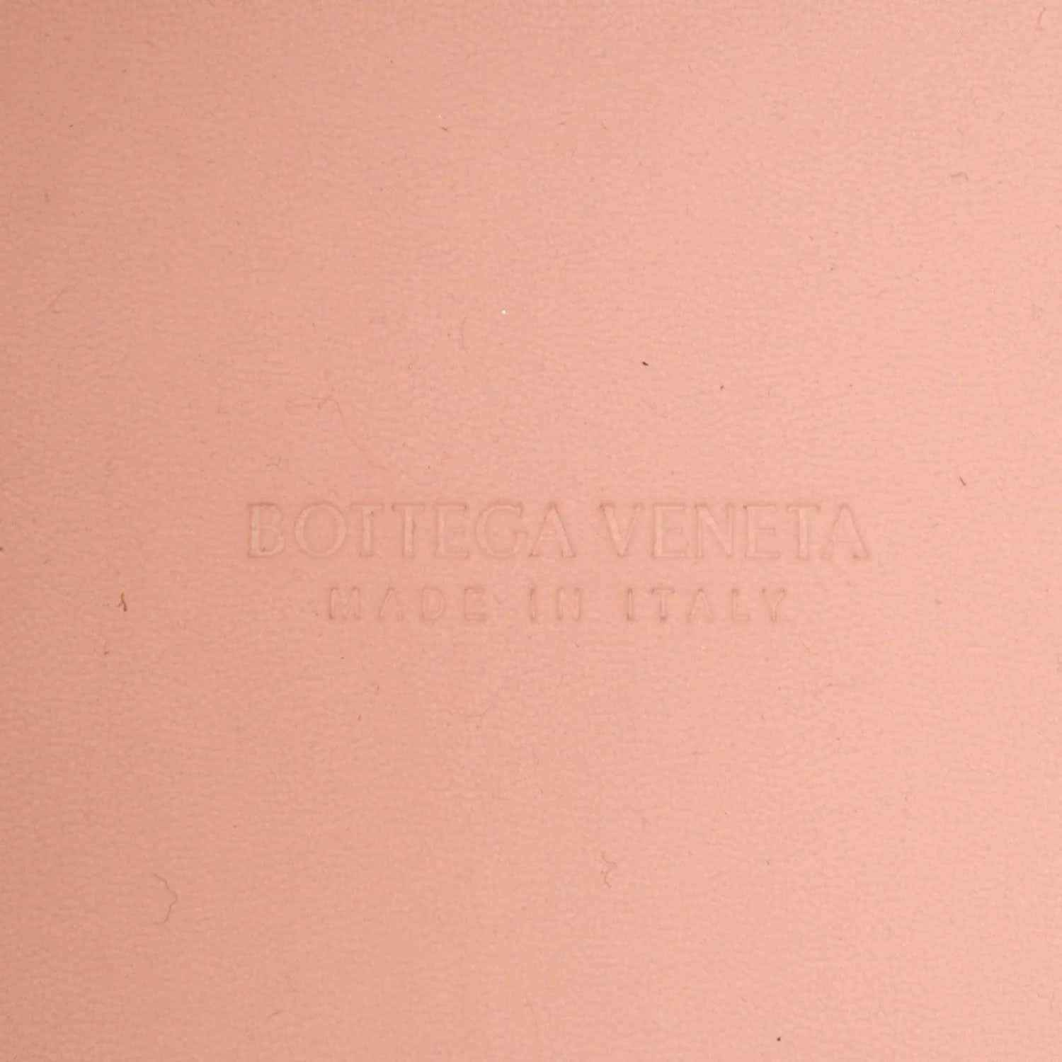 Pink leather bag surface with embossed Bottega Veneta logo