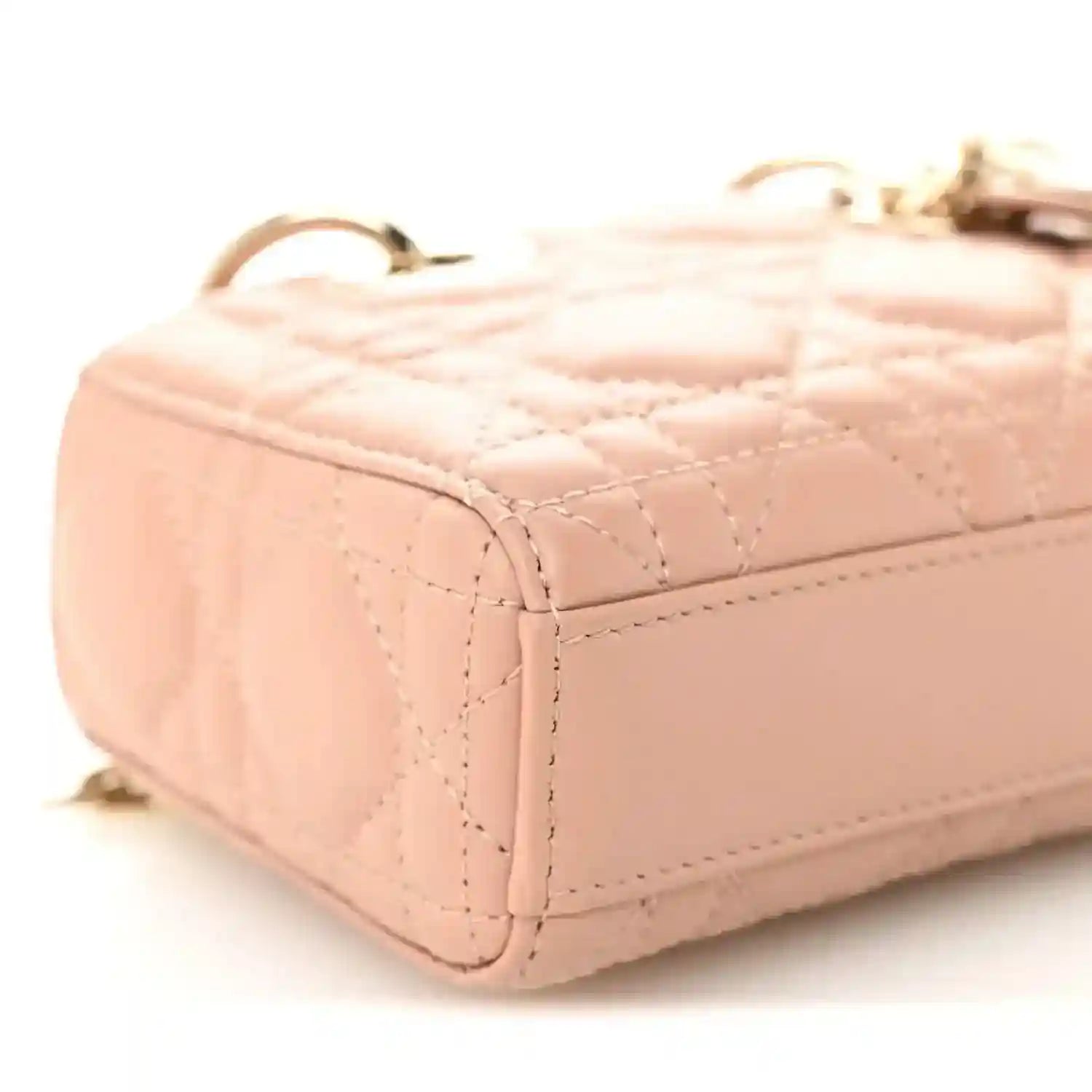 Pink beige quilted micro handbag side with gold-tone chain hardware and curved edge