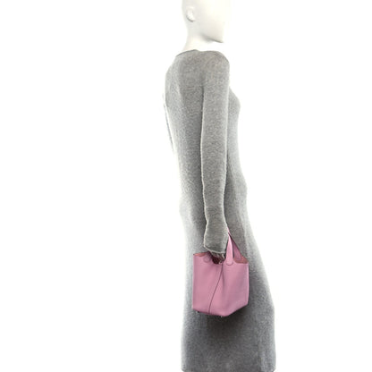 Rose pink mini handbag carried by a model with short top handles