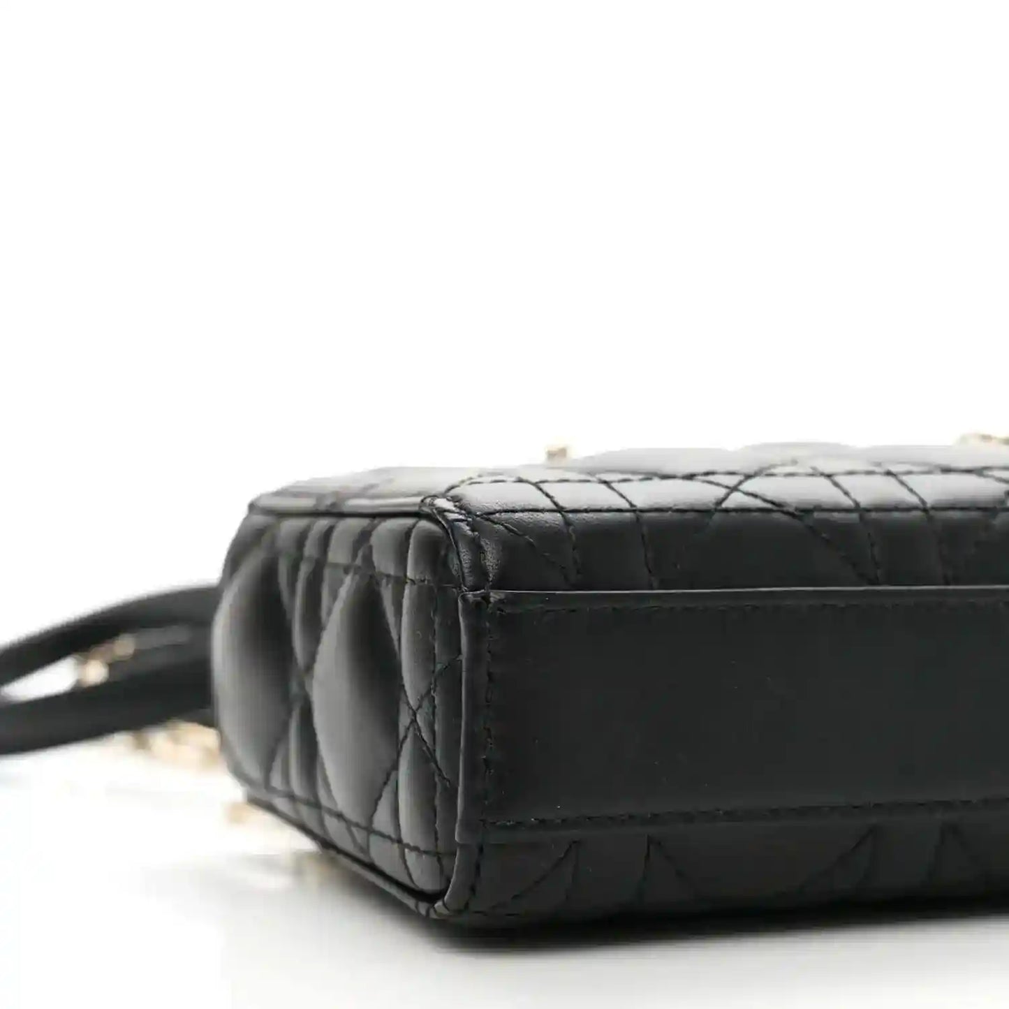 Black lambskin micro handbag with quilted texture and side panel, close-up
