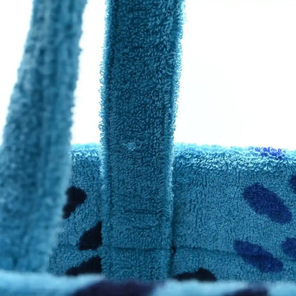 Turquoise terry beach bag with fabric handles and dark star-like pattern