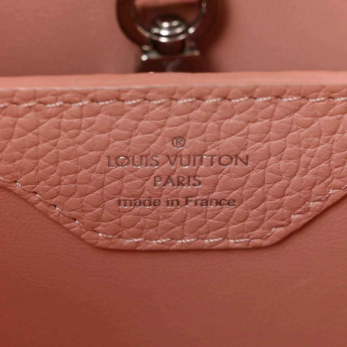 Louis Vuitton Paris leather stamp on pink handbag with visible stitching