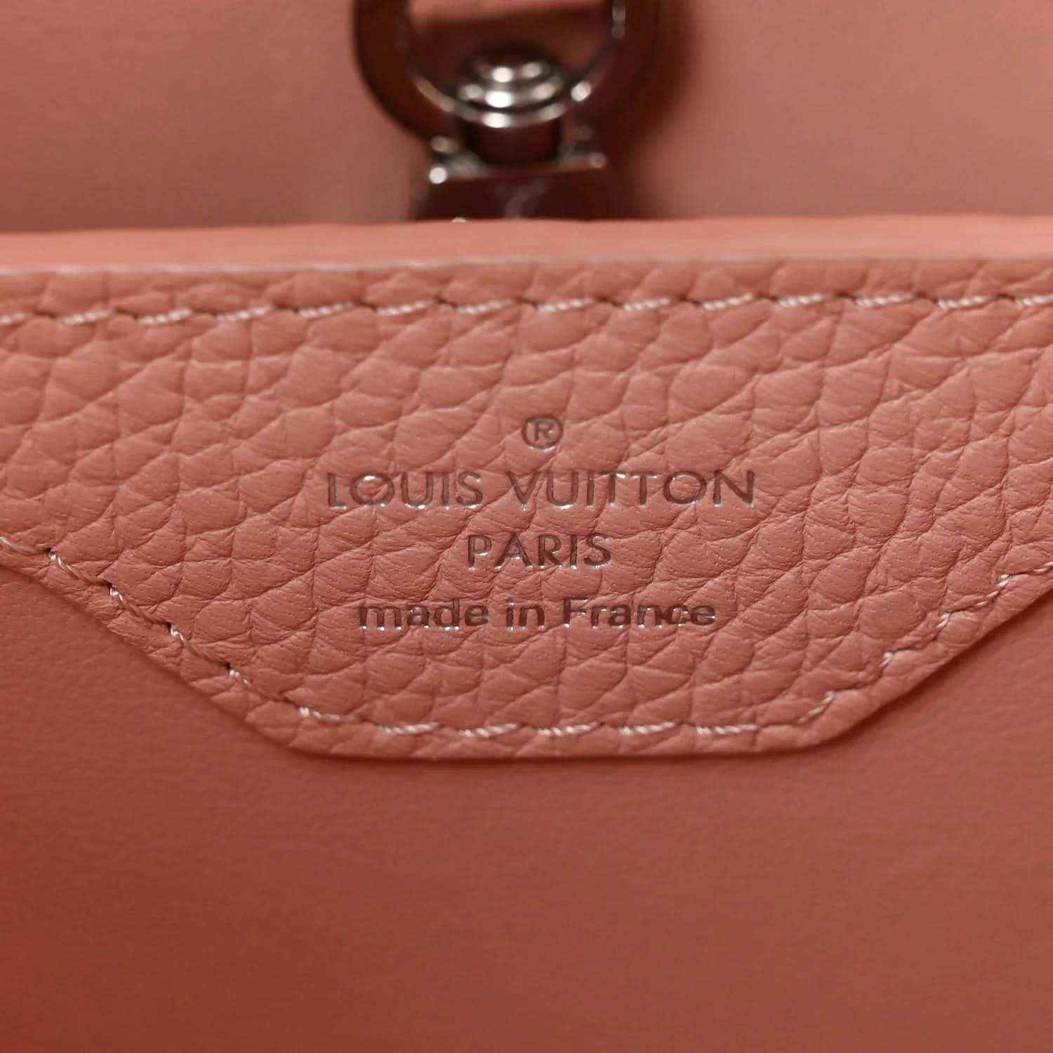 Louis Vuitton Paris leather stamp on pink handbag with visible stitching