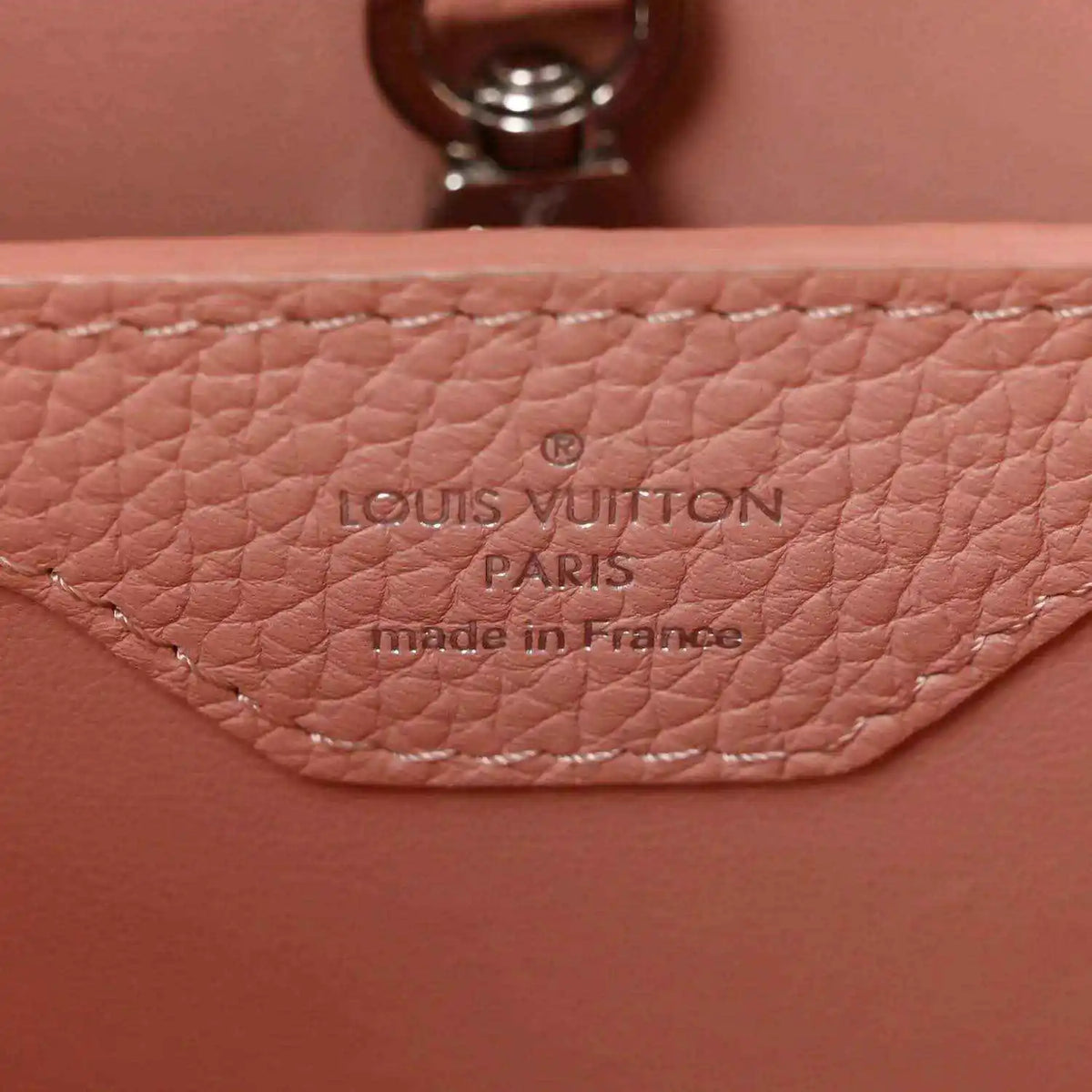 Louis Vuitton Paris leather stamp on pink handbag with visible stitching