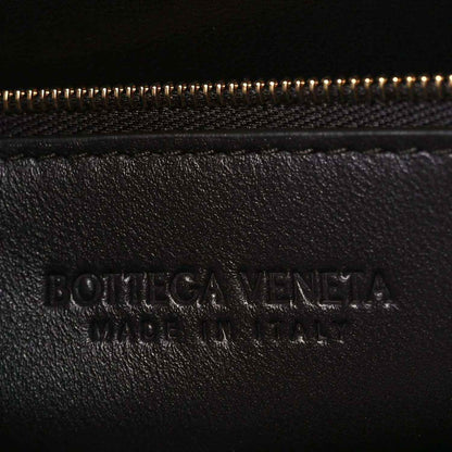 Bottega Veneta embossed logo on dark leather near zipper